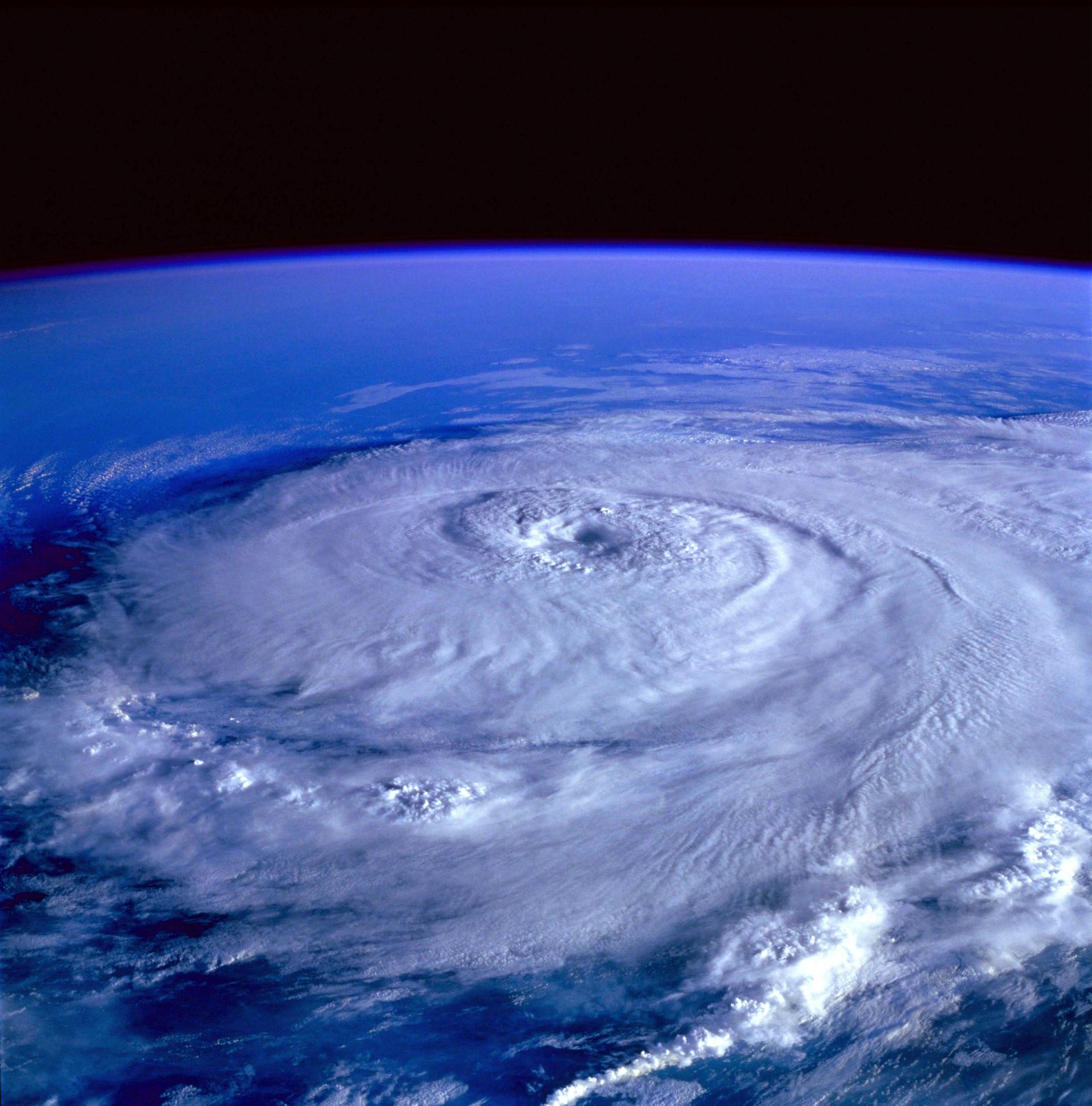 Satellite view of a hurricane displaying a circular cloud formation over the ocean.